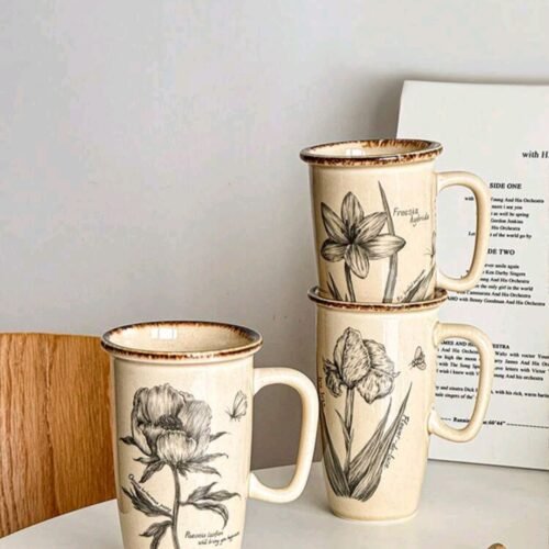 Long ceramic mug with creamy white and peach exterior, one randomly selected flower, brown rim, dishwasher & microwave safe
