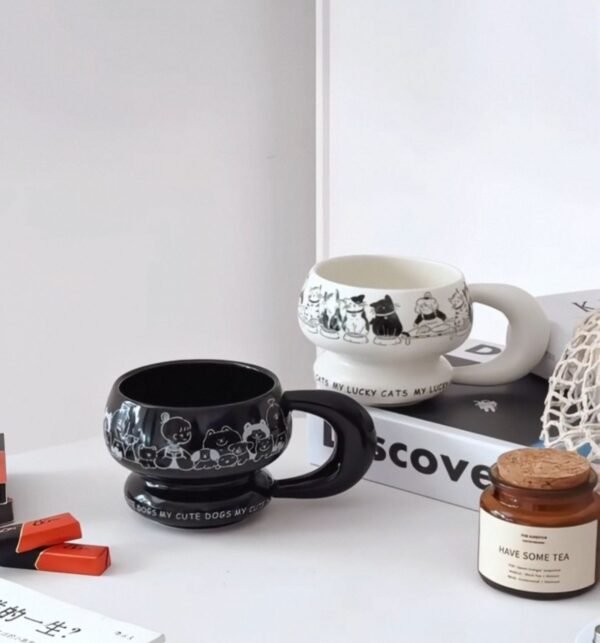 Round sculptural ceramic mug with chunky circular handle, thick rounded rim and base, available in black or white with dog or cat print