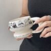 Round sculptural ceramic mug with chunky circular handle, thick rounded rim and base, available in black or white with dog or cat print