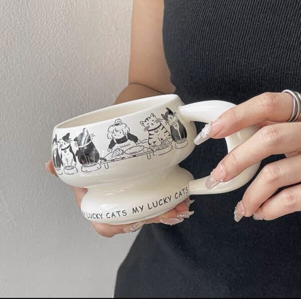 Round sculptural ceramic mug with chunky circular handle, thick rounded rim and base, available in black or white with dog or cat print